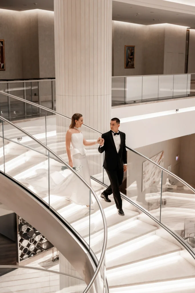 Свадебная фотосессия жениха и невесты на лестнице в холле отеля Hyatt Regency